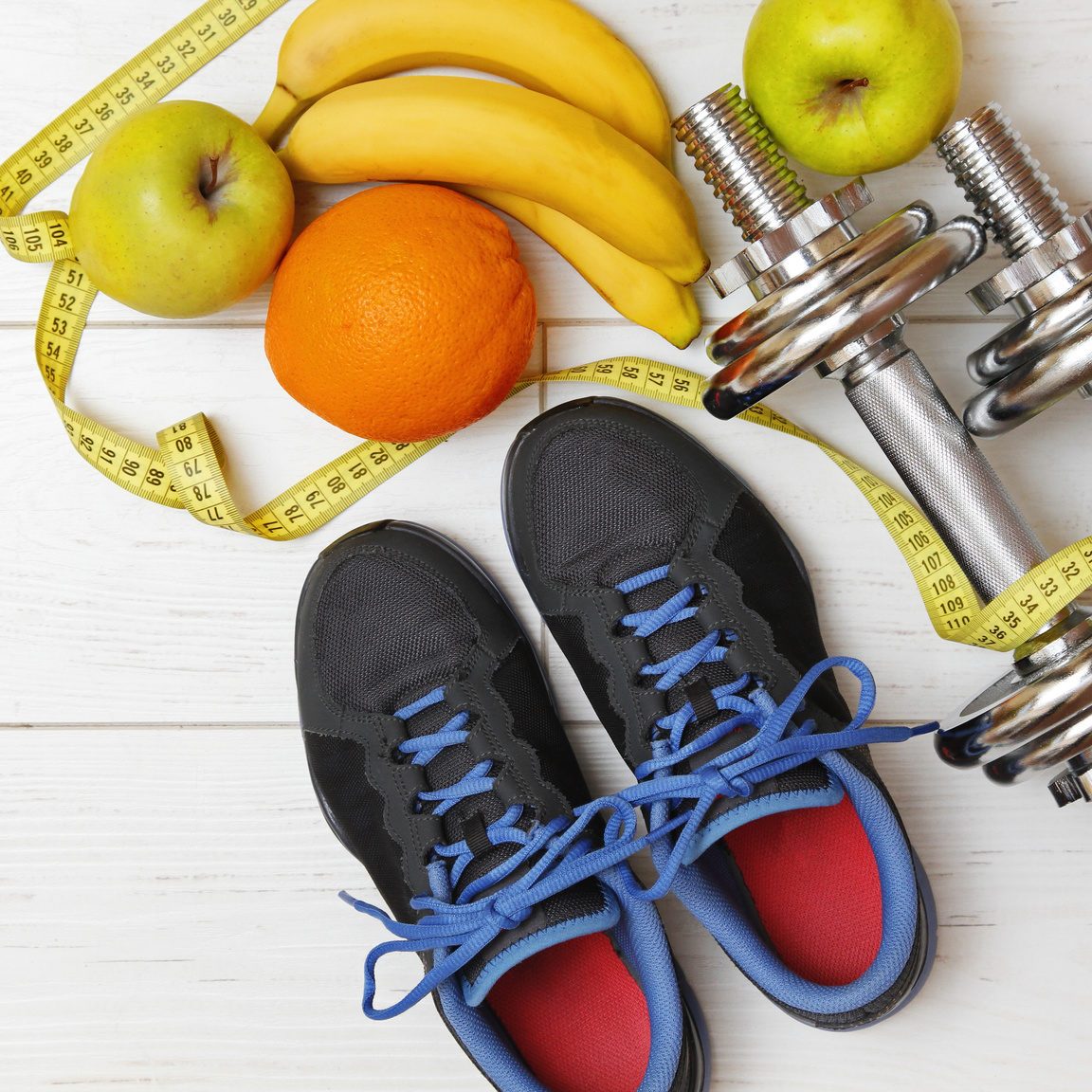 fitness equipment and healthy nutrition on white wooden plank floor